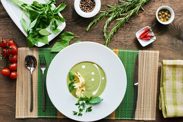 Soup with zucchini in white plate on wooden table - 写真・画像