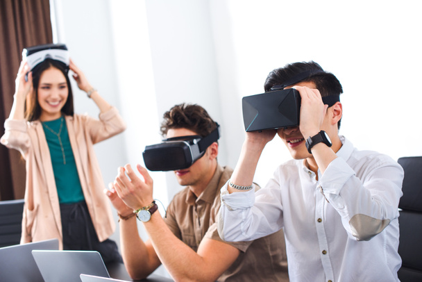 two smiling businessmen using virtual reality headsets at modern office  - Foto, Imagem