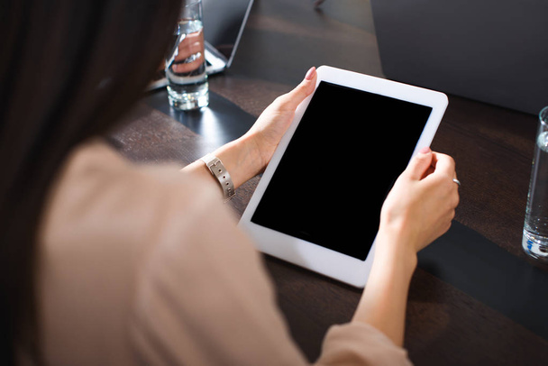 обрізане зображення бізнес-леді, використовуючи цифровий планшет з порожнім екраном в сучасному офісі
 - Фото, зображення