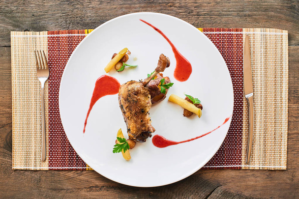 duck leg confit with caramelized apple and potato served on white plate - Zdjęcie, obraz