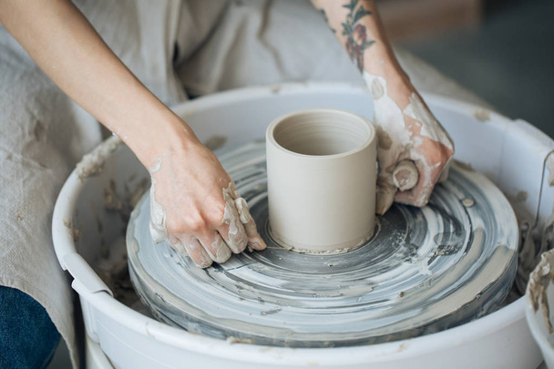 Handcrafted on a potter's wheel,Hands make clay from various items for home and sale in the store and at the exhibition, ceramic items are made in hand, the clay billet becomes a ceramic dish - Foto, imagen
