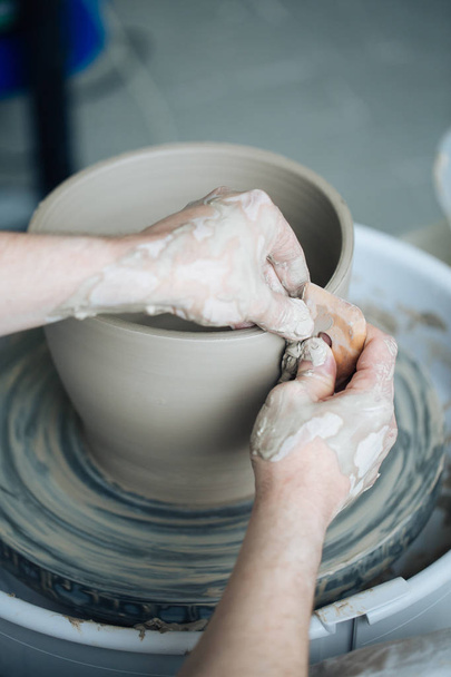 Handcrafted on a potter's wheel,Hands make clay from various items for home and sale in the store and at the exhibition, ceramic items are made in hand, the clay billet becomes a ceramic dish - Foto, Bild