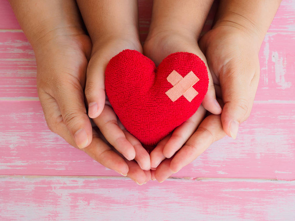manos de adultos y niños sosteniendo el corazón rojo, atención médica, amor, donación de órganos, seguro familiar y RSE y el amor y el concepto de San Valentín
 - Foto, Imagen