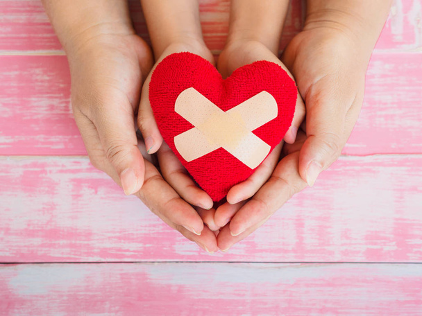 mani di adulti e bambini con cuore rosso, assistenza sanitaria, amore, donazione di organi, assicurazione familiare e CSR e amore e concetto di San Valentino
 - Foto, immagini