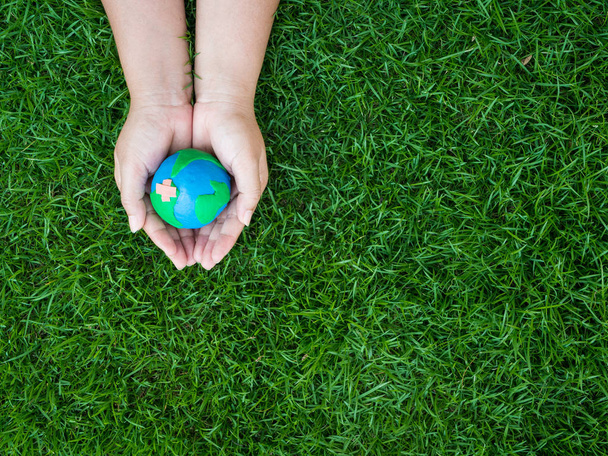 earth in hands and green grass field background. environment save earth concept. - Valokuva, kuva