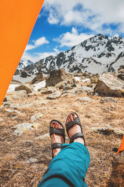 Ноги путешественника отдыхают на вершине горы под открытым небом. Концепция путешествия
 - Фото, изображение