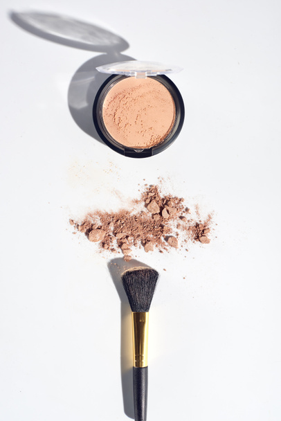 Scattered face powder with brush on white background - Foto, imagen