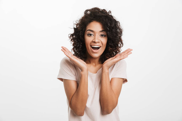 Portrait of a cheerful young afro american woman looking at camera isolated over white background - Фото, изображение