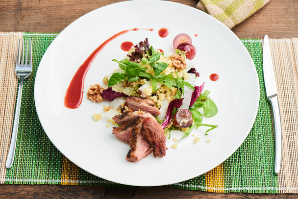 salad with duck breast and daikon with grapes and couscous served on white plate, healthy breakfast concept  - Zdjęcie, obraz
