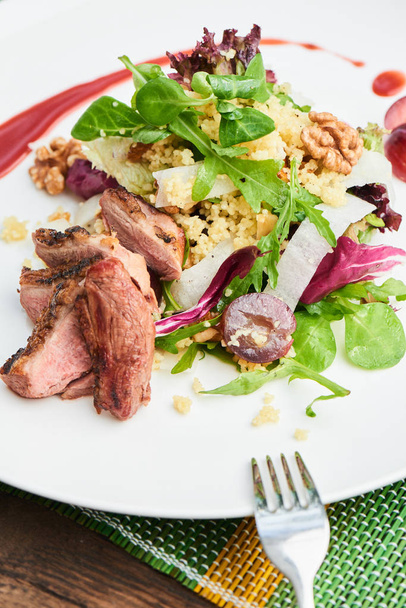 salad with duck breast and daikon with grapes and couscous served on white plate, healthy breakfast concept  - Zdjęcie, obraz