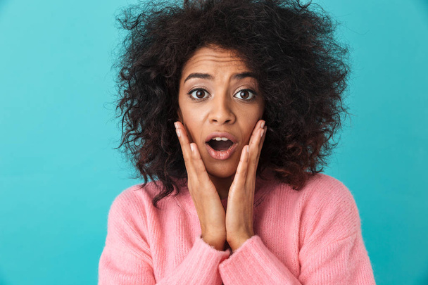Colorful image closeup of surprised woman grabbing face with excited look and open mouth isolated over blue background - Photo, Image