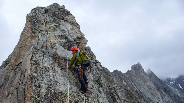 Bergführer führt Klettern auf exponiertem Granitgrat in den Alpen - Foto, Bild