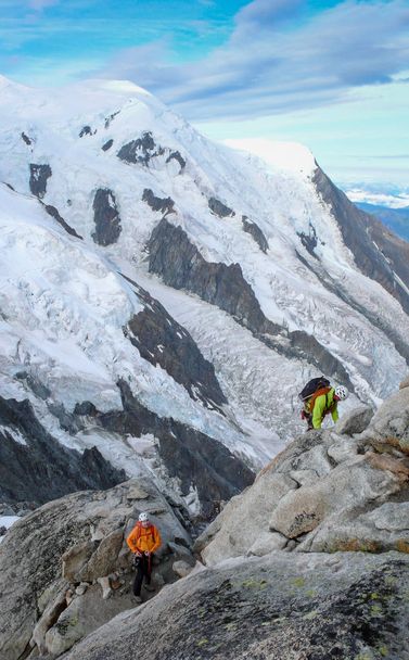 guide de montagne et client masculin sur une crête rocheuse se dirigeant vers un sommet élevé dans les Alpes françaises près de Chamonix
 - Photo, image