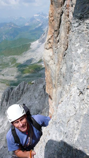 muž horolezec na strmé skále horolezecké trasy ve švýcarských Alpách poblíž Klosters - Fotografie, Obrázek