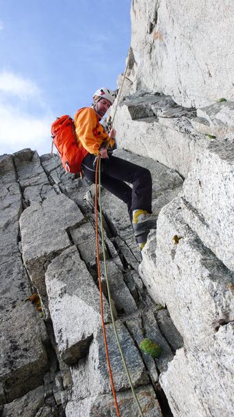 arrampicatore di montagna maschio che scende da una ripida cresta rocciosa nelle Alpi francesi vicino a Chamonix
 - Foto, immagini