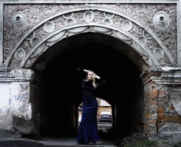  blond woman standing against vintage Italian arch in perspective. - Fotó, kép