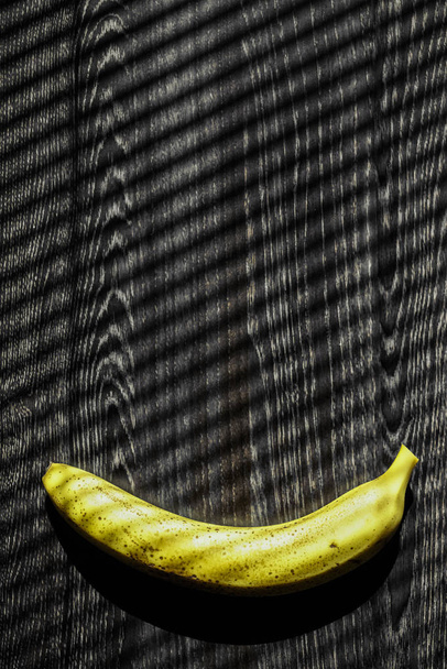  ripe yellow banana  on a black  wooden table.  - Zdjęcie, obraz