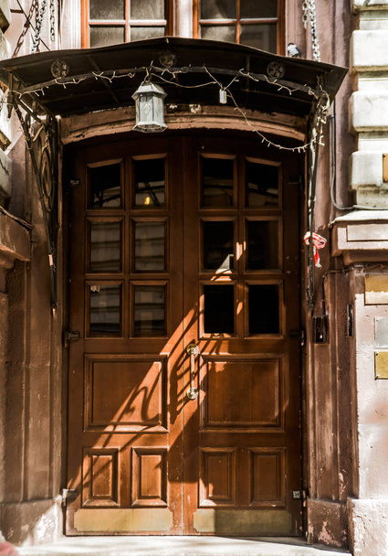 Antigua puerta cerrada de madera con sombra y luz solar. Moscú, Rusia
. - Foto, Imagen