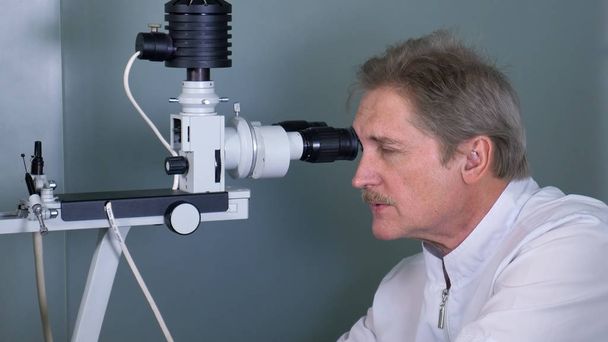 Atención optometrista examinando paciente masculino en lámpara de hendidura en clínica oftalmológica
 - Foto, imagen