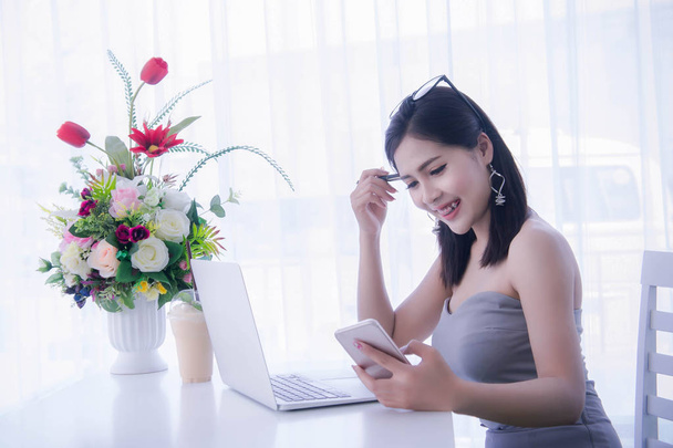 smart girl's using smart phone and working on laptop ,happy time on work, smile and laughing time work , workingwomen get think about work - Photo, Image