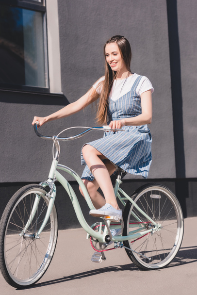 вид спереду молода усміхнена жінка їде на велосипеді
  - Фото, зображення