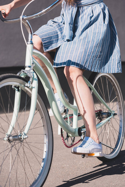 cropped shot of woman riding on bicycle at city street  - Valokuva, kuva