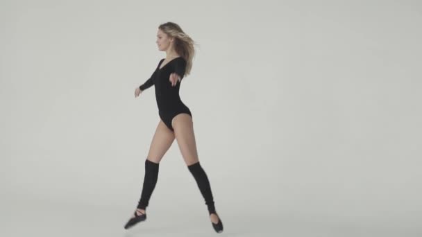 молода дівчина танцює в чорному боді-костюмі і легінсах. Балерина танцює. повільний рух
 - Кадри, відео