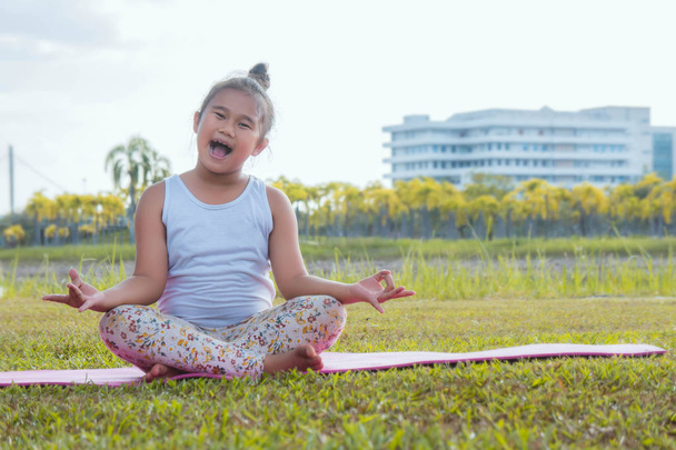 Zdravá jóga dívky a koncentrátu v parku, kluku praxe jógy pro zdraví v hezký den jóga kid - Fotografie, Obrázek