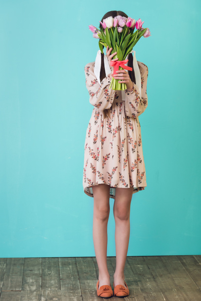stylish girl in summer dress holding tulips, on blue - Foto, afbeelding