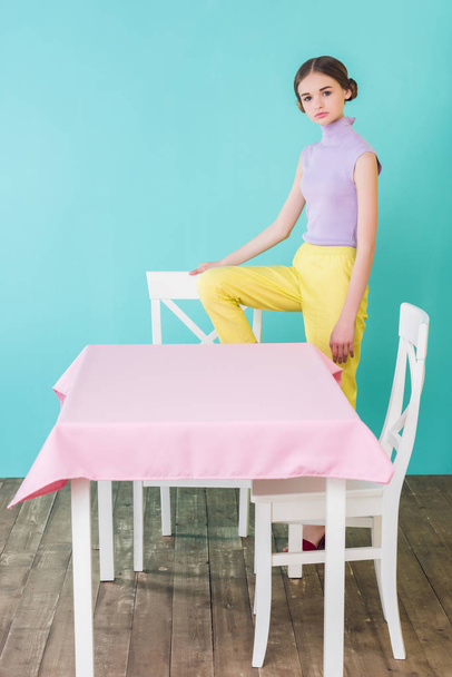 divatos tini lány pózol a asztal és szék étkező  - Fotó, kép