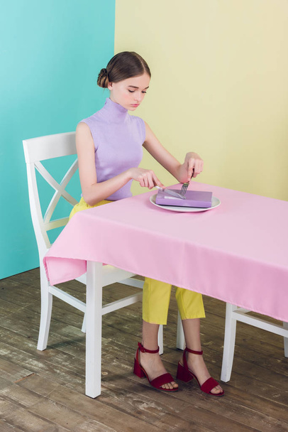 young girl with book on plate in dining room, knowledge concept  - Photo, Image