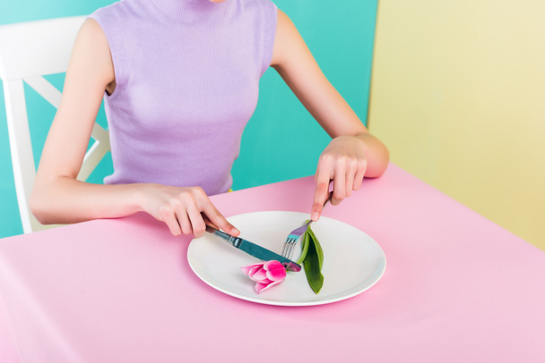 cropped view of girl on diet eating pink tulip flower  - Fotografie, Obrázek