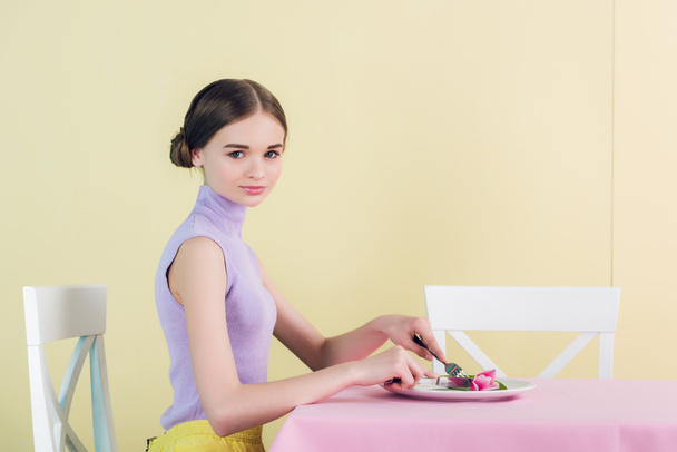beautiful teen girl eating tulip, diet concept - Фото, изображение