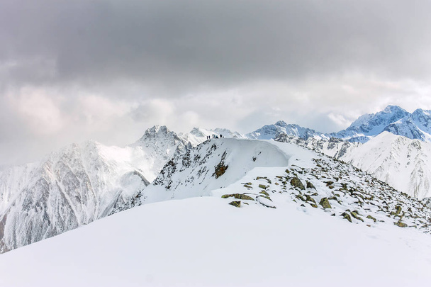 Snowy góry aero zdjęcie drone, zbliża się szczyty i doliny chmur. - Zdjęcie, obraz