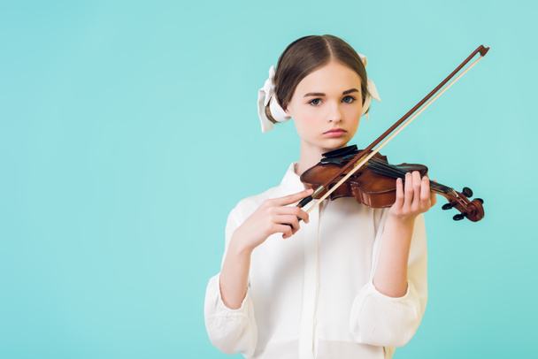 stylish teen girl playing violin, isolated on blue - Foto, immagini