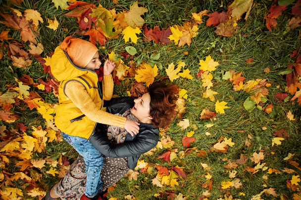 Familia feliz acostada en la hierba al aire libre. Cuidado Parental y Concepto de Amor
 - Foto, imagen