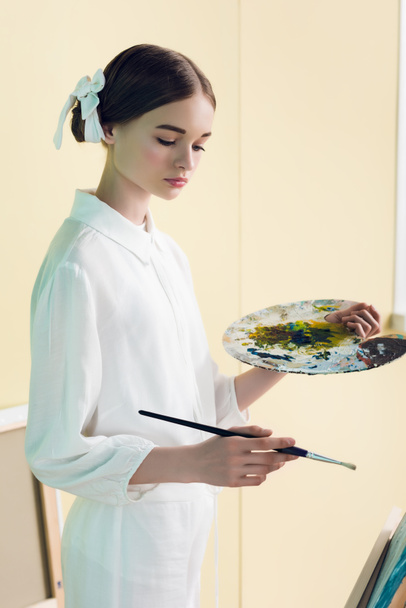 fashionable teenager painting with brush and palette  - Photo, image