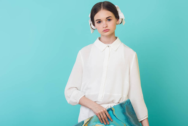 bela adolescente em roupa branca segurando pintura a óleo, isolado em turquesa
 - Foto, Imagem