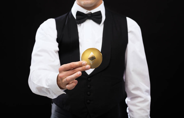 close up of casino dealer holding ethereum coin - Foto, Imagen