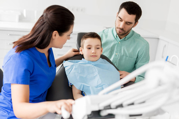 father and son visiting dentist at dental clinic - Foto, Bild
