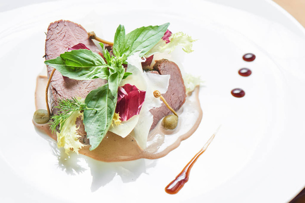 Beef with mushrooms and demi-glace sauce served on white plate - Zdjęcie, obraz