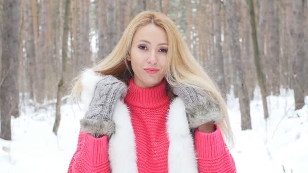 Boldog fiatal nő téli erdőben vagy parkban - Felvétel, videó