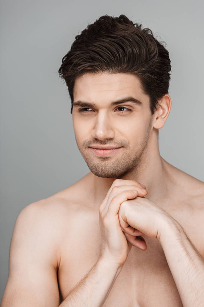 Bellezza ritratto di vestirsi mezzo nudo sorridente giovane uomo guardando lontano isolato su sfondo grigio
 - Foto, immagini