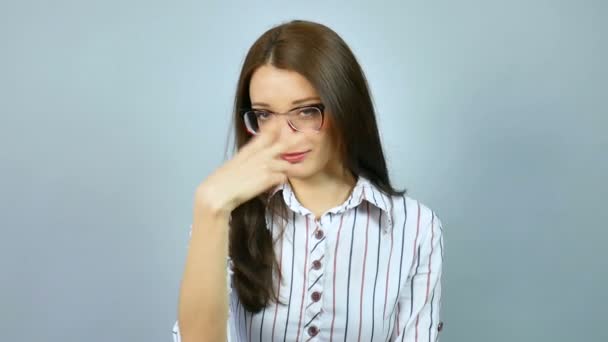 Fiatal szigorú igényes női tanár néz a kamerába, a stúdió a szürke háttér optikai szemüveg viselése. Gesztus im figyel téged. - Felvétel, videó