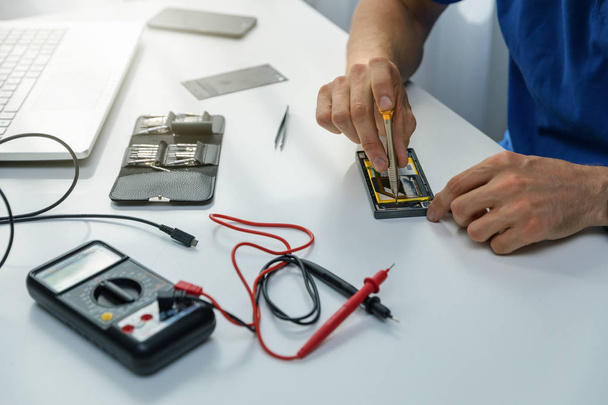 smartphone repairs - technician repairing defective phone - Foto, Bild