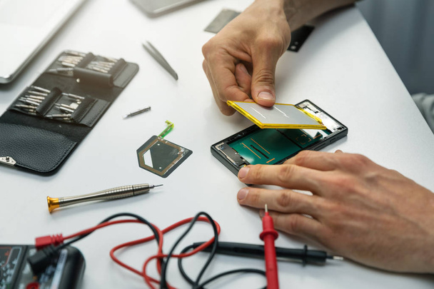 technician installing new battery in phone - Fotoğraf, Görsel