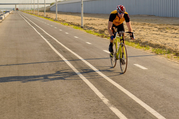 Pyöräilijä polkeminen kilpa pyörä ulkona aurinkoisena päivänä, pyörän polku
. - Valokuva, kuva
