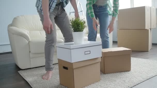Szczęśliwa Młoda para z kartonów przenosi się do nowego mieszkania - Materiał filmowy, wideo