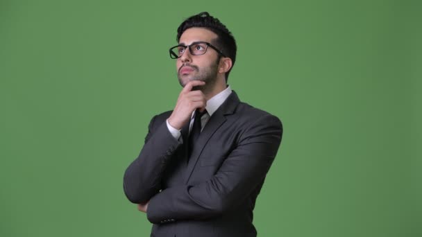Fiatal jóképű szakállas perzsa üzletember zöld háttér - Felvétel, videó