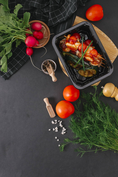 Кормовой состав куриного барбекю с помидорами черри и баклажанами на гриле в черном лотке
 - Фото, изображение